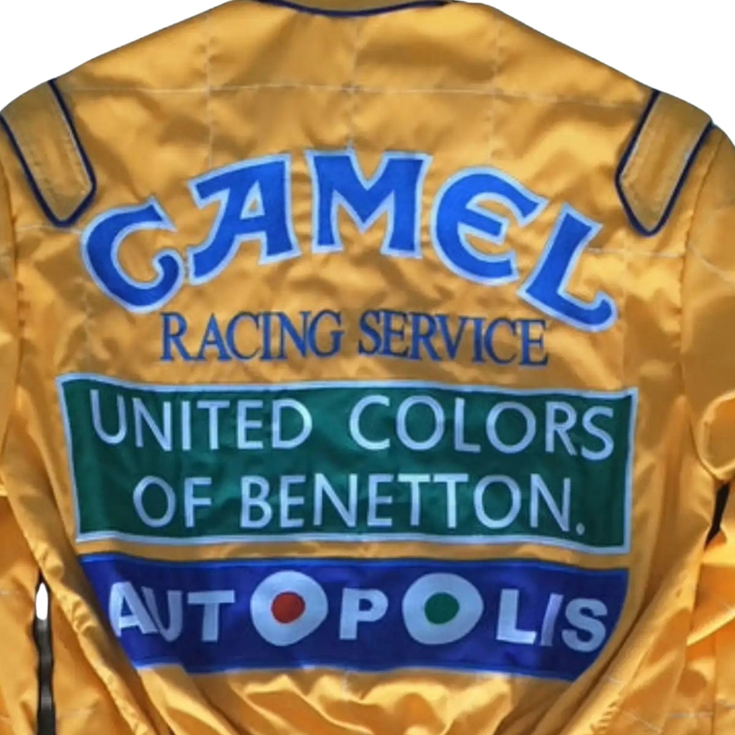 Back view of Schumacher’s 1991 Benetton Ford F1 suit, featuring Camel branding, bright yellow base, and race-stitched team insignia.