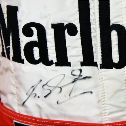 Close-up of Schumacher’s 1997 F1 race suit, displaying detailed stitching and rich red fabric, with sponsor logos highlighting his drive during the 1997 season.