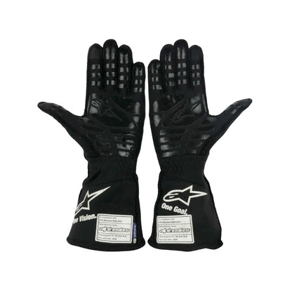 Pair of black Fernando Alonso 2021 F1 racing gloves with visible branding on a white background