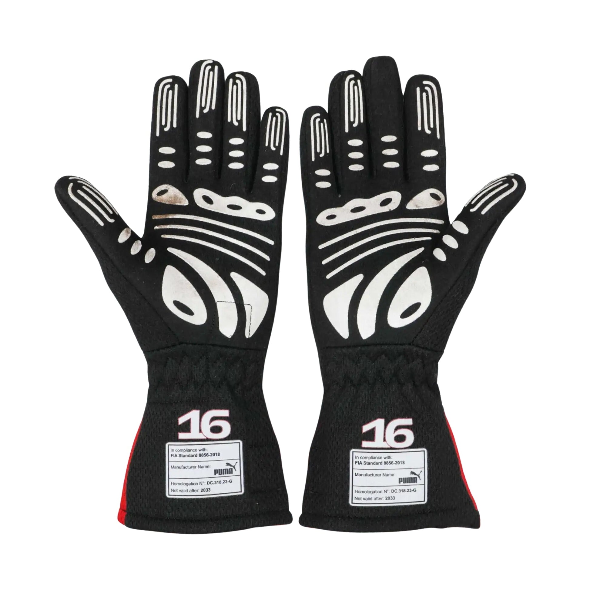 Pair of black Charles Leclerc 2023 F1 racing gloves with white accents and '16' branding on a white background