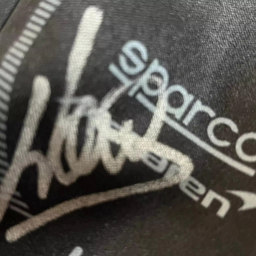 Close-up of a  Lando Norris F1 racing glove logo with 'Hustle' and 'Sparco' text 
