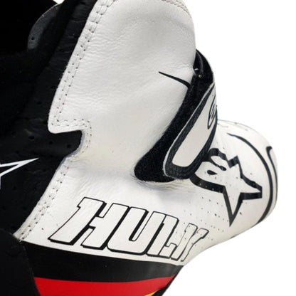 Close-up of a white Nico Hulkenberg 2019 F1 racing shoes with black and red accents, featuring a logo and text.