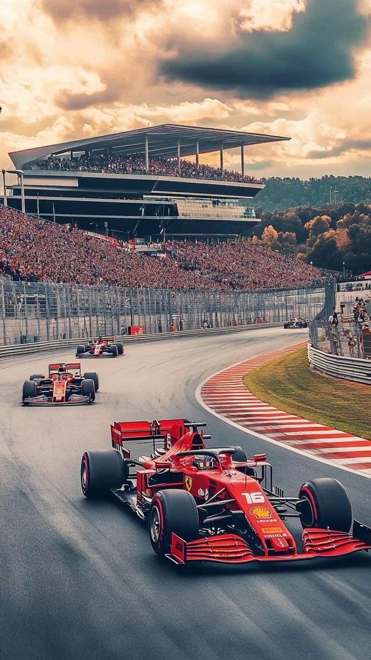 Red Formula 1 car racing on a track with a crowd and grandstand in the background